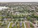 Expansive aerial view of a quiet, tree-lined neighborhood with single-Gathering homes and a glimpse of a nearby lake at 5811 Lake Breeze Ave, Lakeland, FL 33809