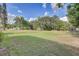 Expansive backyard with lush greenery, mature trees, and play area at 5811 Lake Breeze Ave, Lakeland, FL 33809