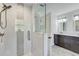 Bathroom featuring double sinks, a glass enclosed shower with neutral tile and modern fixtures at 5811 Lake Breeze Ave, Lakeland, FL 33809