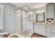Well-lit bathroom features tiled shower, decorative glass, granite countertops and white cabinetry at 5811 Lake Breeze Ave, Lakeland, FL 33809