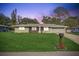 Charming single-story home features a well-manicured lawn and an attached garage at 5811 Lake Breeze Ave, Lakeland, FL 33809