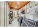 Spacious laundry room with washer, dryer, shelves and wood plank ceiling at 5811 Lake Breeze Ave, Lakeland, FL 33809