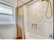Bright bathroom featuring marble-look tile, neutral walls, and a updated shower with gold fixtures at 5811 Lake Breeze Ave, Lakeland, FL 33809