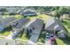 Aerial view of a well-maintained home with a dark roof, surrounded by lush greenery and neighborhood streets at 1035 Stoney Creek Dr, Lakeland, FL 33811