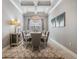 Formal dining room with coffered ceiling, chandelier, neutral decor, and wood-look floors at 1035 Stoney Creek Dr, Lakeland, FL 33811