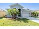 Inviting home with a spacious driveway, lush green lawn, and mature palm trees at 1035 Stoney Creek Dr, Lakeland, FL 33811