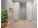 Hallway with wood-look floors, neutral walls, decorative plant and two white doors at 1035 Stoney Creek Dr, Lakeland, FL 33811