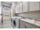 A well-equipped laundry room with modern washer, dryer, sink, and ample cabinet space at 1035 Stoney Creek Dr, Lakeland, FL 33811