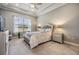 Serene bedroom featuring a tray ceiling, large window, and neutral color scheme for a calming retreat at 1035 Stoney Creek Dr, Lakeland, FL 33811