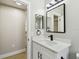 Bright bathroom features a white vanity with a stylish mirror, a large sink, and modern fixtures at 133 Grovepark Dr, Davenport, FL 33837