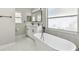 Modern bathroom with a dual sink vanity, freestanding tub, and large framed mirror at 133 Grovepark Dr, Davenport, FL 33837