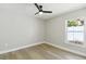 Cozy bedroom features wood flooring, a ceiling fan, and a bright window view at 133 Grovepark Dr, Davenport, FL 33837