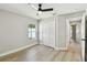 This bedroom features wood flooring, a ceiling fan, a window, and a double door closet at 133 Grovepark Dr, Davenport, FL 33837