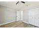 A simple bedroom features a fan, closet, and an entrance to the hallway and bathroom at 133 Grovepark Dr, Davenport, FL 33837
