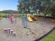 A neighborhood playground features colorful equipment, soft surfacing, and is surrounded by mature trees at 133 Grovepark Dr, Davenport, FL 33837