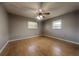 Spacious bedroom featuring wood floors, a ceiling fan, and natural light from two windows at 4621 Queens Point Drive, Lakeland, FL 33813