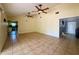 Bright living room featuring tile flooring, ceiling fans and a view of the kitchen at 4621 Queens Point Drive, Lakeland, FL 33813