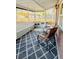 The screened porch with chairs and diamond-patterned carpet offers comfort and style, perfect for outdoor enjoyment at 4746 Wales St, Lake Wales, FL 33859