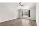 Bedroom boasts wood-look floors, a ceiling fan, and a view of the backyard at 12164 Se 85Th Ct, Belleview, FL 34420