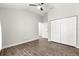 Bedroom features wood-look floors, a ceiling fan, and closet at 12164 Se 85Th Ct, Belleview, FL 34420