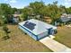 Aerial view of blue single-story home with solar panels and a well-kept lawn at 12164 Se 85Th Ct, Belleview, FL 34420