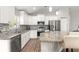 Modern kitchen with white cabinets, stainless steel appliances, and a breakfast bar at 12164 Se 85Th Ct, Belleview, FL 34420