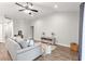 Bright living room boasts wood floors, ceiling fan, and neutral color palette at 12164 Se 85Th Ct, Belleview, FL 34420