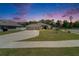 Serene twilight view of a home with a well-kept lawn, spacious driveway, and picturesque neighborhood at 5419 Knights Landing Dr, Lakeland, FL 33810