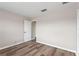 Bright, empty bedroom with wood-look floors and a doorway to the next room at 634 Canna Dr, Davenport, FL 33897