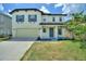 Charming two-story home with blue shutters, covered porch and attached two-car garage at 634 Canna Dr, Davenport, FL 33897