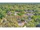 An aerial view showcases a home surrounded by a canopy of lush trees in a vibrant neighborhood at 130 Stag Ridge Ct, Longwood, FL 32779