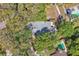 An aerial view highlights a home with a private backyard pool surrounded by mature trees at 130 Stag Ridge Ct, Longwood, FL 32779