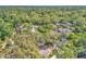 An aerial view showcases a home surrounded by a canopy of lush trees in a vibrant neighborhood at 130 Stag Ridge Ct, Longwood, FL 32779