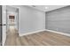 Bedroom featuring wood-look floors, a gray accent wall and a hallway at 130 Stag Ridge Ct, Longwood, FL 32779