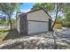 Side view of a home featuring an attached garage, with dark stone accents and mature trees at 130 Stag Ridge Ct, Longwood, FL 32779