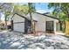 Attractive home showcasing attached garage, dark stone accents, and neat landscaping, shaded by mature trees at 130 Stag Ridge Ct, Longwood, FL 32779
