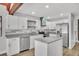 Modern kitchen featuring white cabinets, stainless appliances, island, and stylish backsplash at 130 Stag Ridge Ct, Longwood, FL 32779