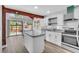 Well-lit kitchen with gray countertops, island, stainless steel appliances, and backyard access at 130 Stag Ridge Ct, Longwood, FL 32779