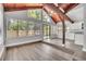 Living room with vaulted wood ceiling, large windows, and flooring that blends seamlessly with the kitchen space at 130 Stag Ridge Ct, Longwood, FL 32779