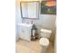 Cozy bathroom features a tile floor, white vanity, and decorative mirror at 201 Lake Bonny E Dr, Lakeland, FL 33801