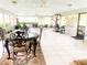 Sunroom features tile flooring, ceiling fan, wrought iron dining set and fitness equipment at 201 Lake Bonny E Dr, Lakeland, FL 33801