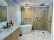 Modern bathroom featuring double vanity, soaking tub, glass enclosed shower, and hexagon/marble flooring at 1315 Olympia Park Cir, Ocoee, FL 34761