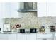 Stylish kitchen featuring white cabinetry and unique backsplash at 1315 Olympia Park Cir, Ocoee, FL 34761