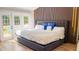 Comfortable primary bedroom featuring bed, wood-look accent wall, and access to backyard at 1315 Olympia Park Cir, Ocoee, FL 34761