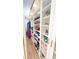 Spacious walk-in closet featuring custom shelving with clothing and shoe storage and glass door cabinets at 1315 Olympia Park Cir, Ocoee, FL 34761