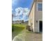 View of the backyard with a green lawn and partial view of the home's exterior at 10601 Burlwood Dr, Leesburg, FL 34788
