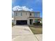 Two-story home featuring an attached garage, manicured lawn, and basketball hoop at 10601 Burlwood Dr, Leesburg, FL 34788