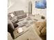 Comfortable living room features plush seating, large TV, and cozy area rug at 10601 Burlwood Dr, Leesburg, FL 34788