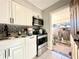 Cozy kitchen with black and white backsplash, stainless appliances, and view to fenced in yard at 2341 Weber St, Lakeland, FL 33801