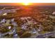 Wide angle aerial shot of the neighborhood featuring beautiful sunset tones and lush trees throughout the landscape at 1968 Pleasant Hill Rd, Kissimmee, FL 34746